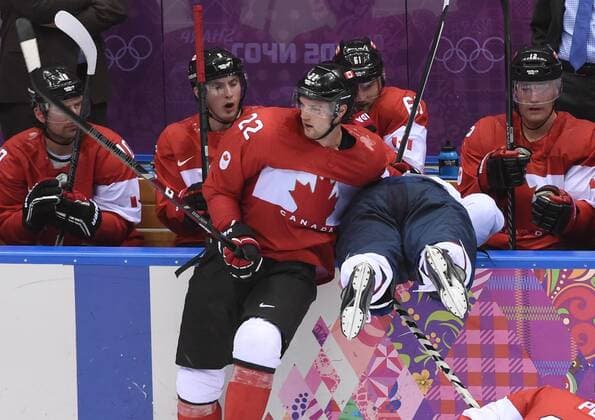 Canada s Jamie Benn (22) checks USA s Phil Kessel into the Canada bench during the play-offs semifinals at the Sochi 2014 Winter Olympics on February 21, 2014 in Sochi, Russia. Canada defeated USA 1-0 to advance to the gold medal game against Sweden. USA will play Finland for the bronze.  OLY20140221714