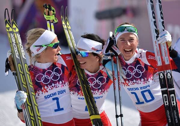 Norway s Marit Bjoergen (2), Kristin Stoermer Steira (10) and Therese Johaug celebrate after finishing second, first and third in the ladies 30 km mass start free cross country race at the Sochi 2014 Winter Olympics on February 22, 2014 in Krasnaya Polyana, Russia. Norway swept the medals with Bjoergen taking gold, Johaug taking silver and Steira winning bronze.  OLY20140222317