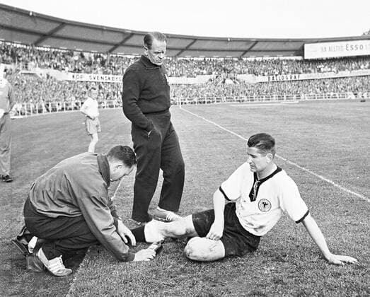 WM in Schweden, Juni 1958, Erich Deuser (l) behandelt Helmut Rahn, Zuschauer ist Bundestrainer Sepp Herberger.
