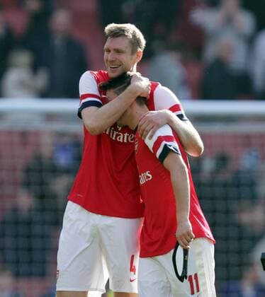 Arsenal v Everton - FA Cup Quarter-Final . . London, UK . . 08.03.2014 Per Mertesacker (A) hugs Mesut Özil (A) at the end. 