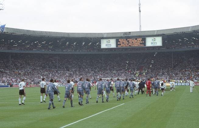 EM 96. Deutschland - England 26.6. in Wembley. 1:1 n.V. u. 6:5 n.Elfm. Einmarsch der Mannschaften - über die Anzeigetafel bitten die die Nationaltrainer Terry Venables und Berti Vogts um Respekt während beider Nationalhymen HM