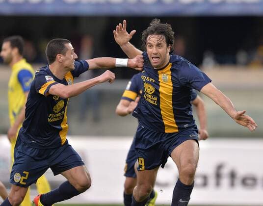 Verona s Luca Toni (R) celebrates scoring during the Italian Serie A football match against Chievo in Verona, Italy, April 5, 2014. Verona won the match 1-0. (Xinhua Alberto Lingria) (SP)ITALY-VERONA-SOCCER-SERIEA 