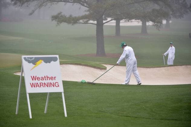Practice range workers work in a sand trap during a practice round prior to the Masters golf tournament at Augusta National Golf Club in Augusta, George, April 7, 2014.  AUG20140407316