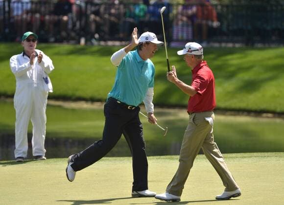 Steve Jones (L) celebrates with Larry Mize after Mize sank his putt on the ninth hole during during the Par 3 Contest during the Masters Tournament at Augusta National Golf Club in Augusta, Georgia, April 8, 2014.  AUG20140409357