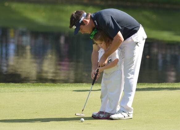 Louis Oosthuizen helps his daughter Jana putt on the ninth green during the Par 3 Contest during the Masters Tournament at Augusta National Golf Club in Augusta, Georgia, April 8, 2014.  AUG20140409340