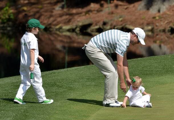 Zack Johnson pick up his daughter Abby Jane as his son Will watches during the Par 3 Contest during the Masters Tournament at Augusta National Golf Club in Augusta, Georgia, April 8, 2014.  AUG20140409346