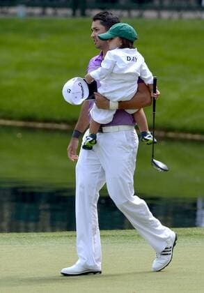 Jason Day carries his son Dash as they walk on the ninth green during the Par 3 Contest during the Masters Tournament at Augusta National Golf Club in Augusta, Georgia, April 8, 2014.  AUG20140409353