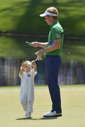 Luke Donald daughter Sophia Ann grabs for her father s putter as he waits to putt on the ninth green during the Par 3 Contest during the Masters Tournament at Augusta National Golf Club in Augusta, Georgia, April 8, 2014.  AUG20140409364