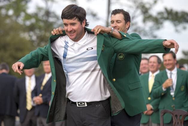 Bubba Watson is presented the green jacket by 2013 Masters champion Adam Scott, after Watson won the 2014 Masters at Augusta National Golf Club in Augusta, Georgia, April 13, 2014. Watson finished eight under par.  AUG20140413409