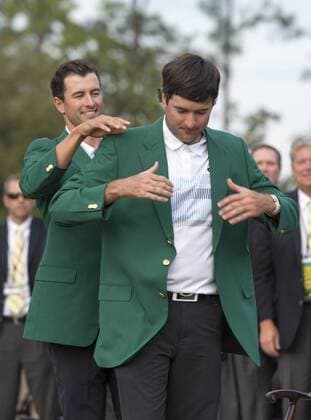 Bubba Watson is presented the green jacket by 2013 Masters champion Adam Scott after Watson won the 2014 Masters at Augusta National Golf Club in Augusta, Georgia, April 13, 2014. Watson finished eight under par.  AUG20140413405