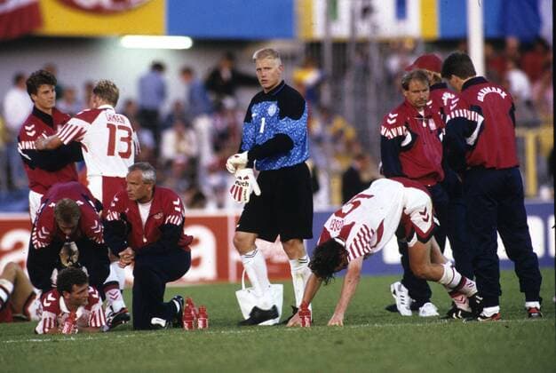 Europameisterschaft 1992 Niederlande - Dänemark 6:7 n. V. Die Dänen in der Verlängerungspause. Li: John Jensen (wird behandelt), daneben Nationaltrainer Richard Möller-Nielsen. Mitte: Torwart Peter Schmeichel. Re: Henrik Andersen beim Stretching. HM