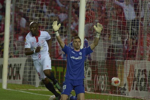 SEVILLE, SPAIN, April 24, 2014: Stephane Mbia (L) scorig the first goal of Sevilla against Vicente Guaita Panadero during the match Sevilla FC - Valencia FC Semifinal leg of the Champions League held at the Sanchez Pizjuan stadium in Seville, Spain. (Photo: Carlos Bouza Cordon Press)  13300