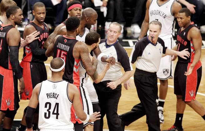 Referees separate Brooklyn Nets Deron Williams and Toronto Raptors Kyle Lowry in the second quarter in Game 3 of the Eastern Conference Quarterfinals at Barclays Center in New York City on April 25, 2014. The Nets defeated the Raptors 102-98 and lead the best of 7 series 2-1.  NYP20140425104