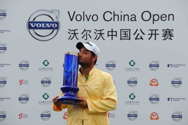Alexander Levy of France kisses his champion trophy during the award ceremony of the Volvo China Open in Shenzhen city, south Chinas Guangdong province, 27 April 2014.  20140427_10874