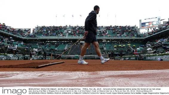 PARIS, May 26, 2014 - Ground worker prepares before using the raincover as rain stops play during the Men s Singles first round match on day 2 of the French Open at Roland Garros in Paris on May 26, 2014. (Xinhua Wang Lili) (SP)FRANCE-PARIS-TENNIS-FRENCH OPEN-DAY 2 