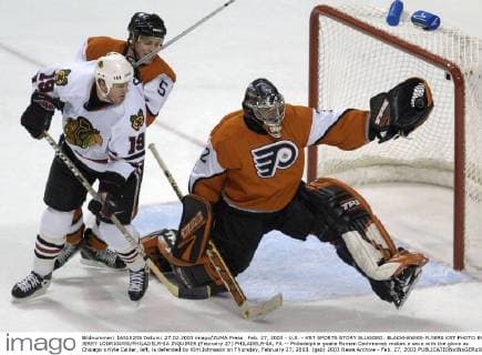 Feb. 27, 2003 - U.S. - KRT SPORTS STORY SLUGGED: BLACKHAWKS-FLYERS KRT PHOTO BY JERRY LODRIGUSS PHILADELPHIA INQUIRER (February 27) PHILADELPHIA, PA -- Philadelphia goalie Roman Cechmanek makes a save with the glove as Chicago s Kyle Calder, left, is defended by Kim Johnsson on Thursday, February 27, 2003. (gsb) 2003 News Archive - Feb. 27, 2003 - ZUMAm67