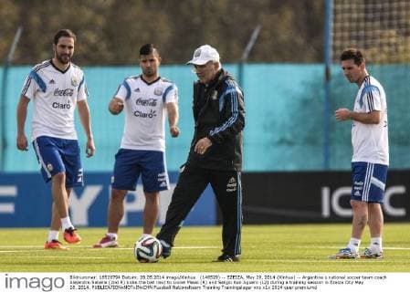 (140529) -- EZEIZA, May 29, 2014 (Xinhua) -- Argentina s national soccer team coach Alejandro Sabella (2nd R) kicks the ball next to Lionel Messi (R) and Sergio Kun Aguero (L2) during a training session in Ezeiza City May 28, 2014. 
