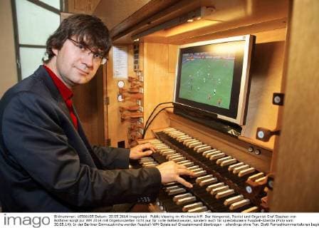 Public Viewing im Kirchenschiff: Der Komponist, Pianist und Organist Graf Stephan von Bothmer sorgt zur WM 2014 mit Orgelkonzerten nicht nur für volle Gotteshaeuser, sondern auch für spektakulaere Fussball-Abende (Foto vom 30.05.14). In der Berliner Emmauskirche werden Fussball-WM-Spiele auf Grossleinwand übertragen - allerdings ohne Ton. Statt Fernsehkommentatoren begleitet von Bothmer die Spiele live auf der maechtigen Kirchenorgel. Schon bei vergangenen Europa- und Weltmeisterschaften hatte der Kuenstler einzelne Spiele mit seiner Orgelmusik begleitet. (Siehe epd-Bericht vom 04.06.2014) Berliner Komponist vertont WM-Spiele auf der Orgel epd EDITORIAL USE ONLY