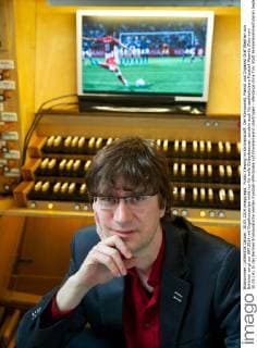 Public Viewing im Kirchenschiff: Der Komponist, Pianist und Organist Graf Stephan von Bothmer sorgt zur WM 2014 mit Orgelkonzerten nicht nur für volle Gotteshaeuser, sondern auch für spektakulaere Fussball-Abende (Foto vom 30.05.14). In der Berliner Emmauskirche werden Fussball-WM-Spiele auf Grossleinwand übertragen - allerdings ohne Ton. Statt Fernsehkommentatoren begleitet von Bothmer die Spiele live auf der maechtigen Kirchenorgel. Schon bei vergangenen Europa- und Weltmeisterschaften hatte der Kuenstler einzelne Spiele mit seiner Orgelmusik begleitet. (Siehe epd-Bericht vom 04.06.2014) Berliner Komponist vertont WM-Spiele auf der Orgel epd EDITORIAL USE ONLY