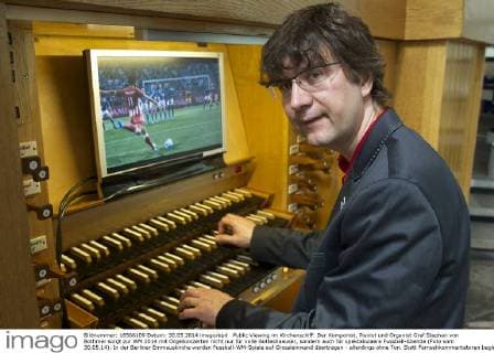 Public Viewing im Kirchenschiff: Der Komponist, Pianist und Organist Graf Stephan von Bothmer sorgt zur WM 2014 mit Orgelkonzerten nicht nur für volle Gotteshaeuser, sondern auch für spektakulaere Fussball-Abende (Foto vom 30.05.14). In der Berliner Emmauskirche werden Fussball-WM-Spiele auf Grossleinwand übertragen - allerdings ohne Ton. Statt Fernsehkommentatoren begleitet von Bothmer die Spiele live auf der maechtigen Kirchenorgel. Schon bei vergangenen Europa- und Weltmeisterschaften hatte der Kuenstler einzelne Spiele mit seiner Orgelmusik begleitet. (Siehe epd-Bericht vom 04.06.2014) Berliner Komponist vertont WM-Spiele auf der Orgel epd EDITORIAL USE ONLY