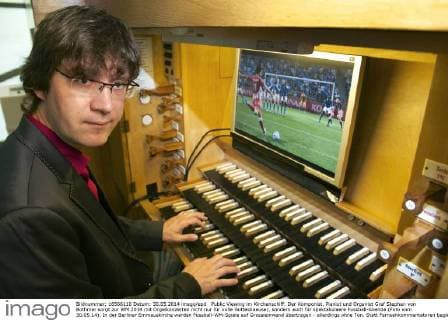 Public Viewing im Kirchenschiff: Der Komponist, Pianist und Organist Graf Stephan von Bothmer sorgt zur WM 2014 mit Orgelkonzerten nicht nur für volle Gotteshaeuser, sondern auch für spektakulaere Fussball-Abende (Foto vom 30.05.14). In der Berliner Emmauskirche werden Fussball-WM-Spiele auf Grossleinwand übertragen - allerdings ohne Ton. Statt Fernsehkommentatoren begleitet von Bothmer die Spiele live auf der maechtigen Kirchenorgel. Schon bei vergangenen Europa- und Weltmeisterschaften hatte der Kuenstler einzelne Spiele mit seiner Orgelmusik begleitet. (Siehe epd-Bericht vom 04.06.2014) Berliner Komponist vertont WM-Spiele auf der Orgel epd EDITORIAL USE ONLY