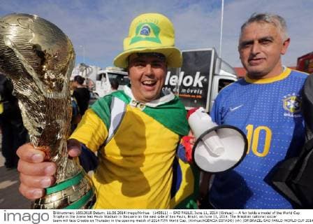 (140611) -- SAO PAULO, June 11, 2014 (Xinhua) -- A fan holds a model of the World Cup Trophy in the Arena Sao Paulo Stadium in Itaquera on the east side of Sao Paulo, Brazil, on June 11, 2014. The Brazilian national soccer team will face Croatia on Thursday in the opening match of 2014 FIFA World Cup. (Xinhua AGENCIA ESTADO) (rh) (SP)BRAZIL-SAO PAULO-WORLD CUP 2014-FANS 