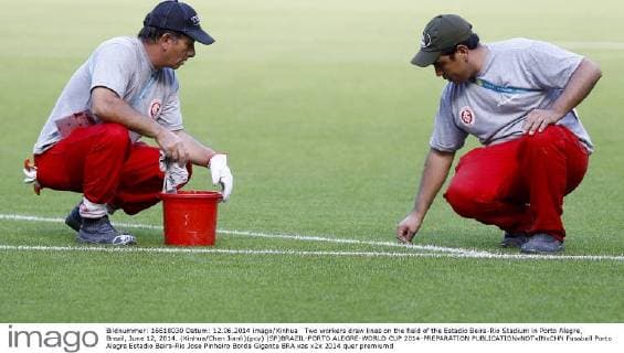 Two workers draw lines on the field of the Estadio Beira-Rio Stadium in Porto Alegre, Brazil, June 12, 2014. (Xinhua Chen Jianli)(pcy) (SP)BRAZIL-PORTO ALEGRE-WORLD CUP 2014-PREPARATION 