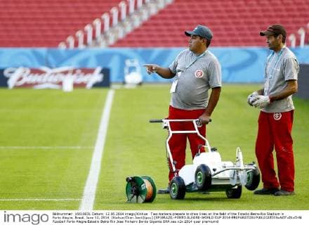 Two workers prepare to draw lines on the field of the Estadio Beira-Rio Stadium in Porto Alegre, Brazil, June 12, 2014. (Xinhua Chen Jianli)(pcy) (SP)BRAZIL-PORTO ALEGRE-WORLD CUP 2014-PREPARATION 