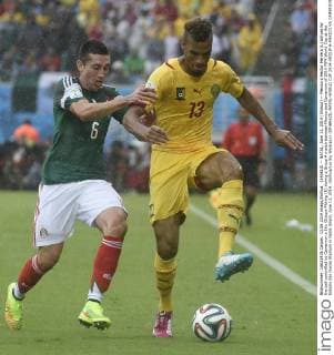 (140613) -- NATAL, June 13, 2014 (Xinhua) -- Mexico s Hector Herrera (L) strives for the ball controlled by Cameroon s Eric Choupo Moting (R) during a Group A match between Mexico and Cameroon of 2014 FIFA World Cup at the Estadio das Dunas Stadium in Natal, Brazil, June 13, 2014. (Xinhua Lui Siu Wai)(pcy) (SP)BRAZIL-NATAL-WORLD CUP 2014-GROUP A-MEXICO VS CAMEROON 