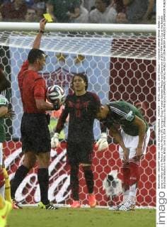 (140613) -- NATAL, June 13, 2014 (Xinhua) -- Colombian referee Wilmar Roldan (L) gives a yellow card to Mexico s Hector Moreno (R) during a Group A match between Mexico and Cameroon of 2014 FIFA World Cup at the Estadio das Dunas Stadium in Natal, Brazil, June 13, 2014. (Xinhua Lui Siu Wai)(pcy) (SP)BRAZIL-NATAL-WORLD CUP 2014-GROUP A-MEXICO VS CAMEROON 