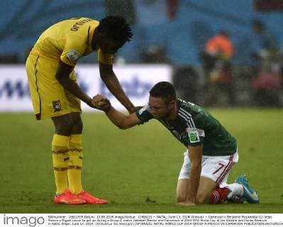 (140613) -- NATAL, June 13, 2014 (Xinhua) -- Cameroon s Benjamin Moukandjo (L) helps Mexico s Miguel Layun to get up during a Group A match between Mexico and Cameroon of 2014 FIFA World Cup at the Estadio das Dunas Stadium in Natal, Brazil, June 13, 2014. (Xinhua Lui Siu Wai)(pcy) (SP)BRAZIL-NATAL-WORLD CUP 2014-GROUP A-MEXICO VS CAMEROON 