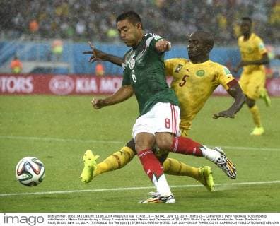 (140613) -- NATAL, June 13, 2014 (Xinhua) -- Cameroon s Dany Nounkeu (R) competes with Mexico s Marco Fabian during a Group A match between Mexico and Cameroon of 2014 FIFA World Cup at the Estadio das Dunas Stadium in Natal, Brazil, June 13, 2014. (Xinhua Lui Siu Wai)(pcy) (SP)BRAZIL-NATAL-WORLD CUP 2014-GROUP A-MEXICO VS CAMEROON 