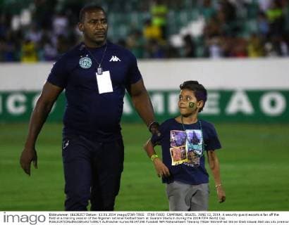ITAR-TASS: CAMPINAS, BRAZIL. JUNE 13, 2014. A security guard escorts a fan off the field at a training session of the Nigerian national football team at Guarani Stadium during the 2014 FIFA World Cup.  Aufmacher kurios RE147298