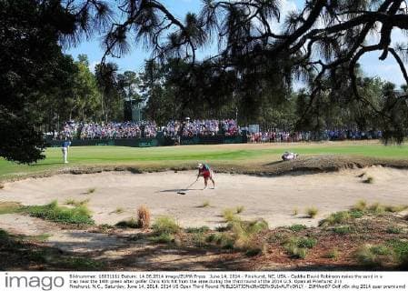 June 14, 2014 - Pinehurst, NC, USA - Caddie David Robinson rakes the sand in a trap near the 14th green after golfer Chris Kirk hit from the area during the third round of the 2014 U.S. Open at Pinehurst 2 in Pinehurst, N.C., Saturday, June 14, 2014. 2014 US Open Third Round - ZUMAm67