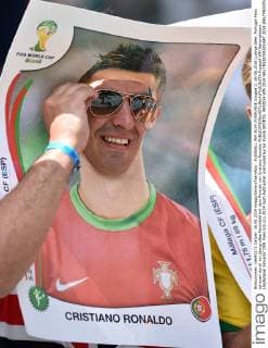 FUSSBALL WM 2014 VORRUNDE Gruppe G 16.06.2014 Lustige Idee: Portugal Fans schauen durch ein übergroßes Paninibild mit dem Portrait von Cristiano Ronaldo
