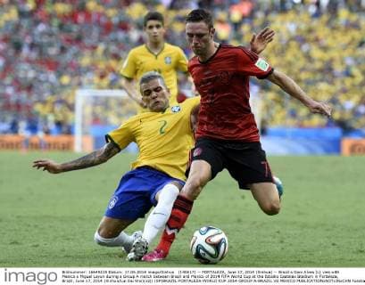 (140617) -- FORTALEZA, June 17, 2014 (Xinhua) -- Brazil s Dani Alves (L) vies with Mexico s Miguel Layun during a Group A match between Brazil and Mexico of 2014 FIFA World Cup at the Estadio Castelao Stadium in Fortaleza, Brazil, June 17, 2014.(Xinhua Lui Siu Wai)(xzj) (SP)BRAZIL-FORTALEZA-WORLD CUP 2014-GROUP A-BRAZIL VS MEXICO 
