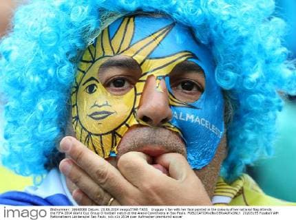 Uruguay s fan with her face painted in the colours of her national flag attends the FIFA 2014 World Cup Group D football match at the Arena Corinthians in Sao Paulo.  20205195