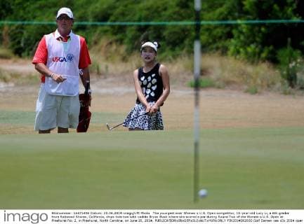 The youngest ever Women s U.S. Open competitor, 11-year-old Lucy Li, a 6th grader from Redwood Shores, California, chips hole two with caddie Bryan Bush where she scored a par during Round Two of the Women s U.S. Open at Pinehurst No. 2, in Pinehurst, North Carolina, on June 20, 2014.  PIN2014062020