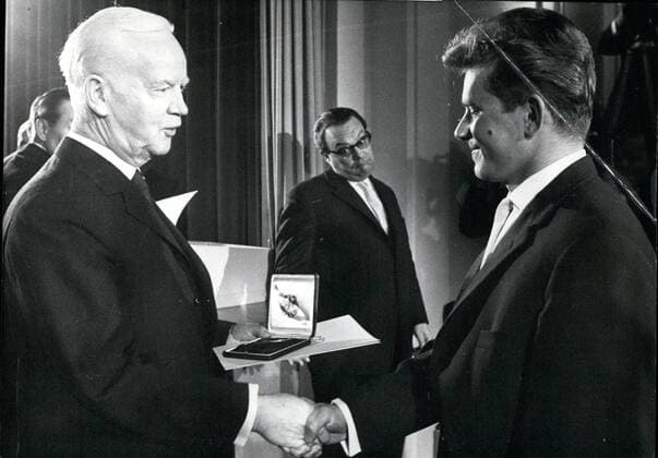 Olympia, Historie, Olympische Winterspiele 1960 in Squaw Valley Dec. 12, 1960 - Silver Laurel for Olympic Winners. German President Heinrich Luebke presented 57 winners of medals at the Olympic Games in Squaw Valley and Rome with the Silver Medal Laurel on Friday, December 9th, 1960. The Silver Laurel is the highest decoration in German Sport. OPS The Federal President giving the Silver Laurel to Georg Thoma of the Black Forest who won the gold medal in the north combination during the Olympic Games in Squaw Valley. In the center the press reviewer to the Federal President, Readerscheid who is looking as if he would envy the sportsman for the silver Laurel.  - ZUMAk09