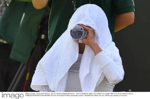 Vera Zvonareva stays cool under her towel with a drink on Centre Court. 