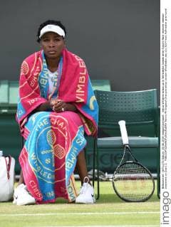 Venus Williams wraps up in Wimbledon towels while Kurumi Nara receives medical treatment on Court 3. 