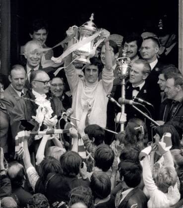 Fußball, Trainerhistorie, FC Arsenal May 10, 1971 - Arsenal given big reception after their F.A. Cup final win.: A crowd of about 200,000 checred Arsenal, the F.A. Cup winners to a civic reception at Islington town hall yesterday. The team drove a mile through the streets from Highbury to the town hall in an open-top double decker bus, parading the three trophies they had won this season - the League Championship trophy, F.A. Cup and Youth Cup. Photo shows to the roar of thousands of supporters, Arsenal s captain Frank McLintock, displayed the F.A. Cup during a civic reception at Islington town hall. Behind the Mayor, Ald. Robin Goodman, is Mr. Bertie Mee, Arsenal s manager. - ZUMAk09