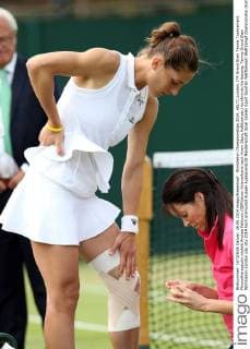 Wimbledon Championships 2014, AELTC,London, ITF Grand Slam Tennis Tournament, Physiotherapeutin wickelt Andrea Petkovic (GER)einen Knieverband nach ihrem Sturz,Halbkoerper,Hochformat,Verletzung,