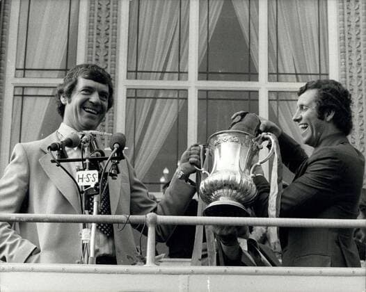 May 03, 1976 - F.A. Cup WINNERS RETURN TO SOUTHAMPTON: F.A. Cup winners, Southampton returned home yesterday to a welcome from ore than 160,000 people. The team were driven around the town in a open top double-Decker bus and at the end of the 19 mile route the Mayor MRS. ELEANOR PUGH gave the team the freedom of the Southampton. Photo shows Manager LAWRIE McMENEMY and player Peter Osgood celebrate the victory with champagne on the balcony of the Guildhall.  - ZUMAk09