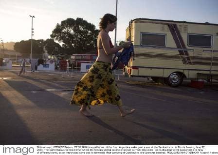 A fan from Argentina walks past a van at the Sambadrome, in Rio de Janeiro, June 27, 2014. The world famous Sambadrome, where the famous samba parade of annual Carnival take place, were allocated to the supporters and fans of different teams, as an improvised camp site to terminate their camping at Copacabana and Ipanema beaches. 