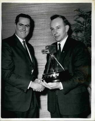 Dec. 12, 1959 - John Surtees is chosen as TV s Sportsman of the Year: John Surtess the fastest man in the world on motorcycle was last night chosen as Sports Personality of 1959 by B.B.C. Television s Sportsview Surtess world motor-cycling champion for the year in succession, was presented with the trophy a miniature television camera by Sir John Hunt, of Everest fame. Photo shows two speed champions meet for mutual congratulations. On the left Jack Brabham, the world champion racing car driver, shakes hand with John Surtees seen holding his trophy after being chosen Sports Personality of 1959 last night.  - ZUMAk09