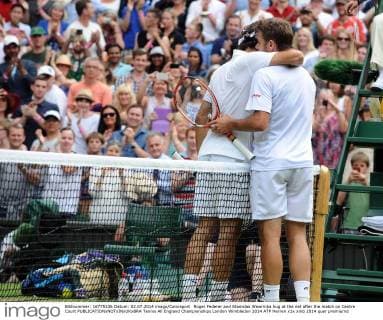 Roger Federer and Stanislas Wawrinka hug at the net after the match on Centre Court 