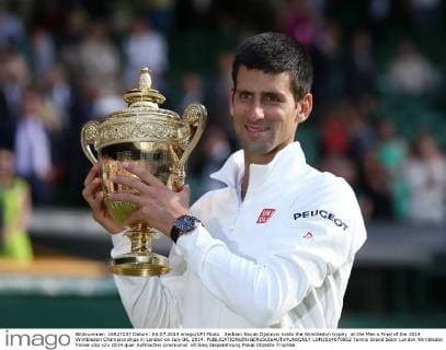 Serbian Novak Djokovic holds the Wimbledon trophy at the Men s Final of the 2014 Wimbledon Championships in London on July 06, 2014.  LON2014070602