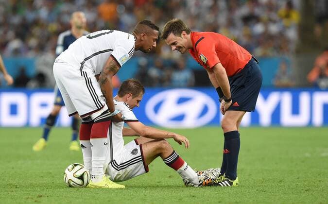 FUSSBALL WM 2014 FINALE Deutschland - Argentinien 13.07.2014 Jerome Boateng (li, Deutschland) und Schiedsrichter Nicola Rizzoli (re, Italien) kuemmern sich um Philipp Lahm (Mitte, Deutschland)