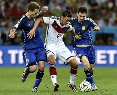 RIO DE JANEIRO, July 13, 2014 (Xinhua) -- Germany s Mesut Ozil (C) vies with Argentina s Lucas Biglia (L) and Lionel Messi during the final match between Germany and Argentina of 2014 FIFA World Cup at the Estadio do Maracana Stadium in Rio de Janeiro, Brazil, on July 13, 2014. Germany won 1-0 over Argentina after 120 minutes and took its fourth World Cup title on Sunday. (Xinhua Qi Heng)(pcy) (SP)BRAZIL-RIO DE JANEIRO-WORLD CUP 2014-FINAL-GERMANY VS ARGENTINA 